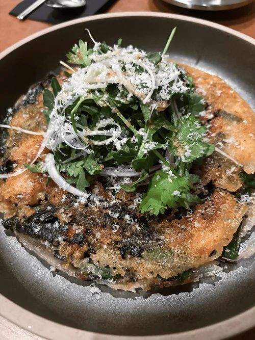 Seafood jeon topped with herbs and grated nut