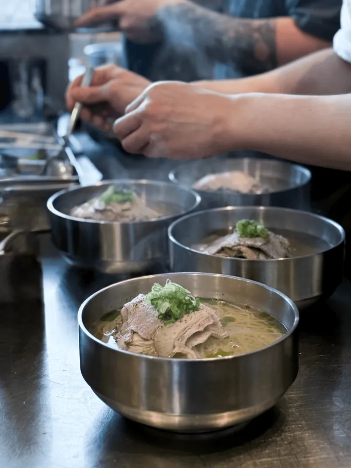 Bowls of gomtang being prepared in the kitchen
