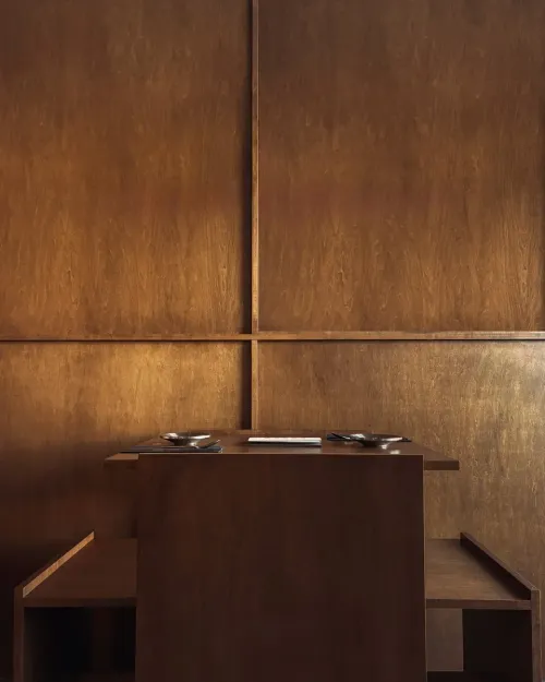 A two-seat table set against warm wood-panelled walls