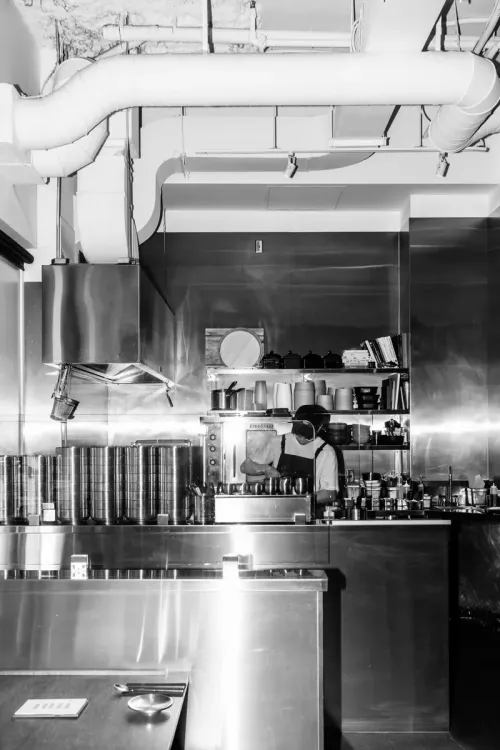 A black and white view of a chef at work in the open kitchen
