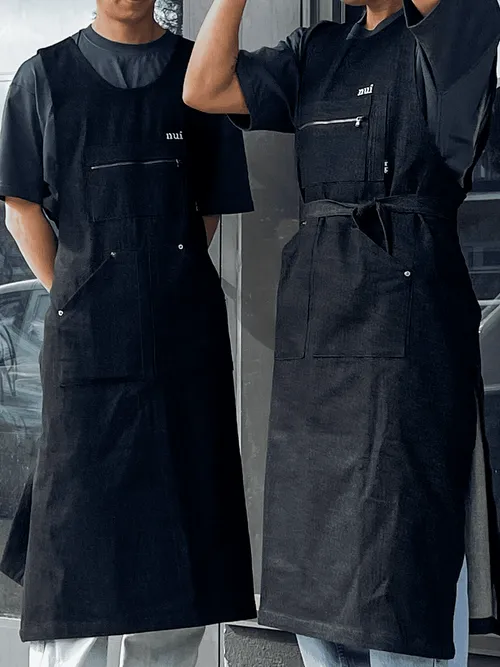 Two Nui staff members in black aprons